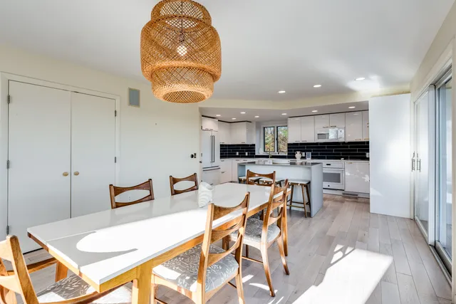 a living room with stainless steel appliances kitchen island granite countertop furniture and a wooden floor