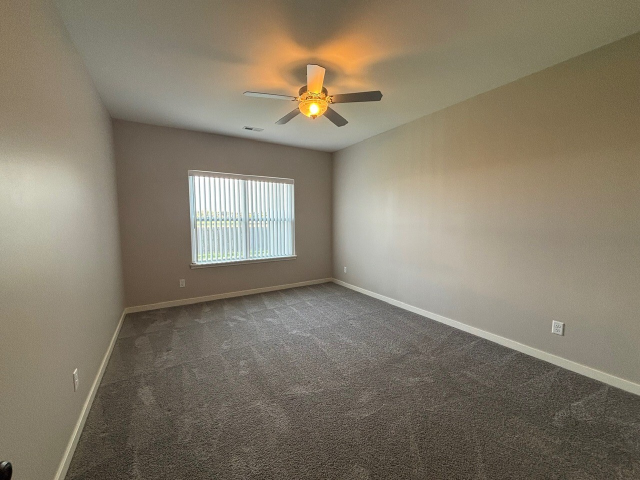 608 Anjali Court, Unit L Sycamore, IL 60178 - Photo 17 of 26 an empty room with a chandelier fan and windows