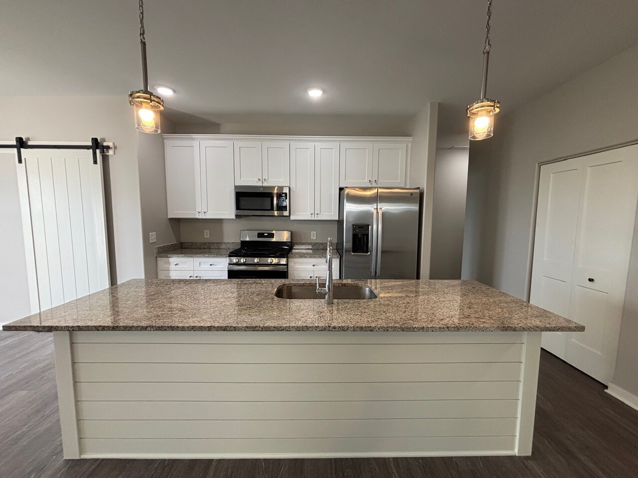 608 Anjali Court, Unit L Sycamore, IL 60178 - Photo 5 of 26 a kitchen with kitchen island granite countertop stainless steel appliances a refrigerator a stove a sink and cabinets