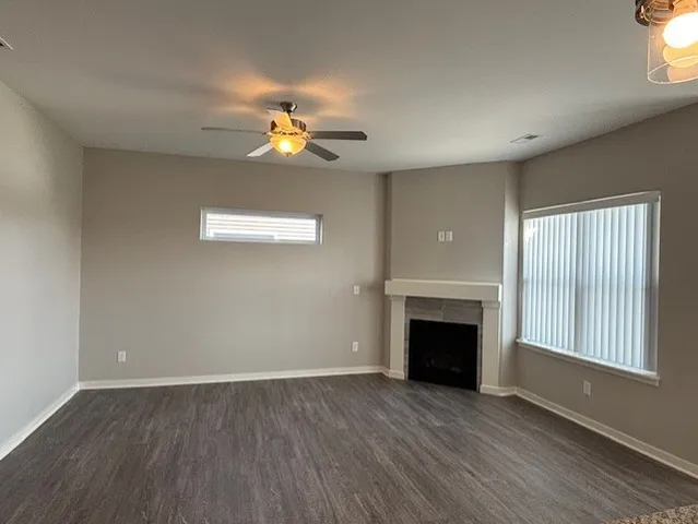 an empty room with windows and fireplace