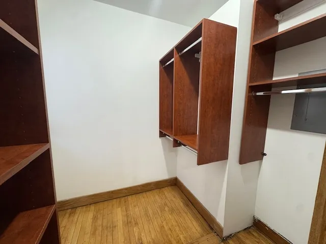 a view of walk in closet with clothes and shoes