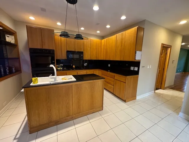 a kitchen with stainless steel appliances kitchen island granite countertop a refrigerator a oven a sink and dishwasher