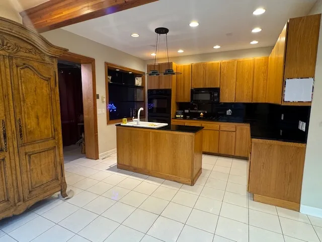 a kitchen with stainless steel appliances kitchen island granite countertop a refrigerator and a stove top oven
