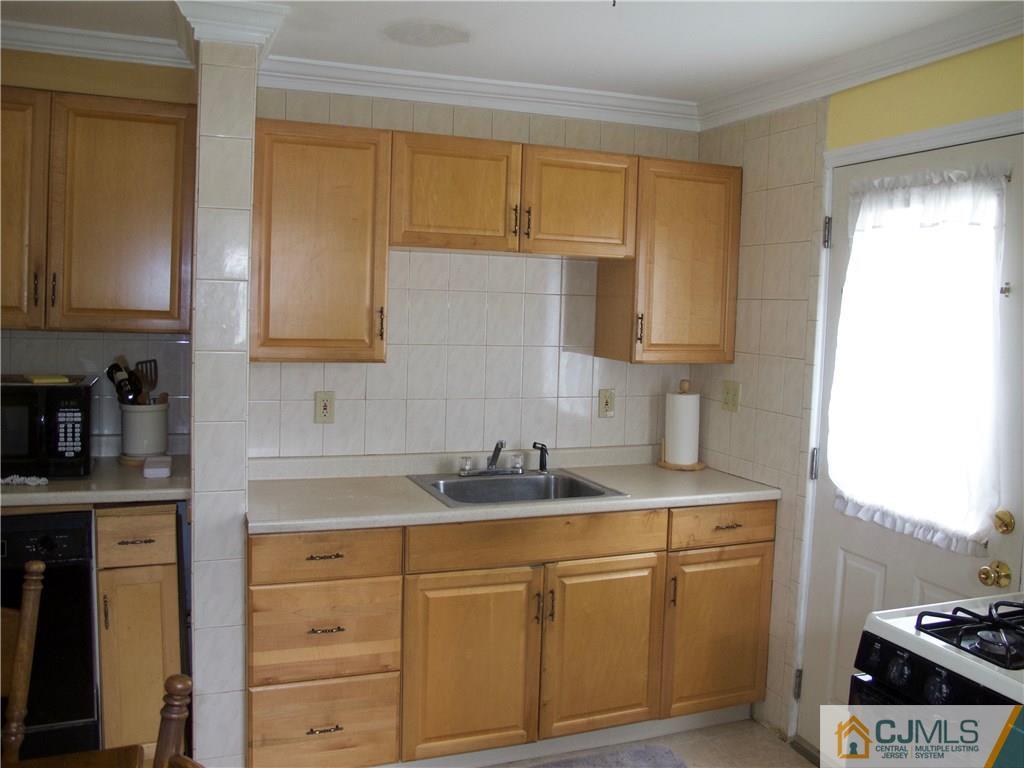 1707 Holly Road North Brunswick, NJ 08902 - Photo 16 of 21 a kitchen with cabinets appliances a sink and a window