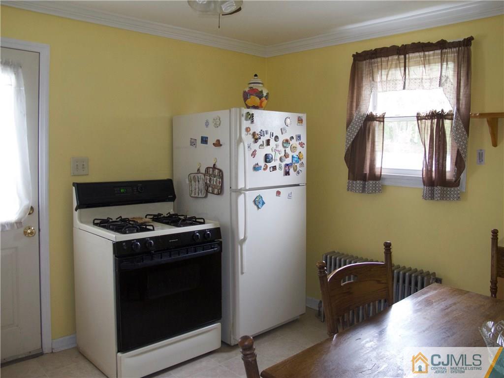 1707 Holly Road North Brunswick, NJ 08902 - Photo 17 of 21 a kitchen with a stove and wooden floor