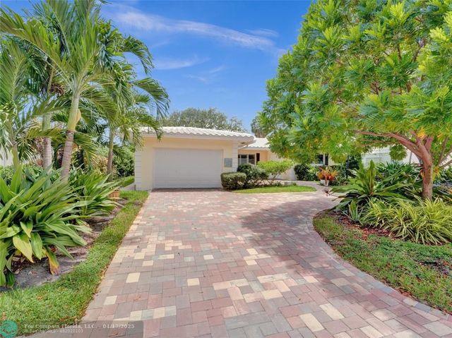 a view of a yard with plants and a fountain