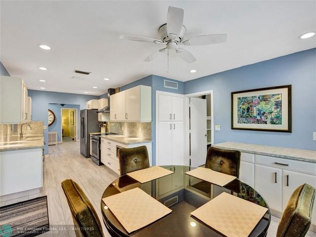 a living room with furniture kitchen view and a chandelier