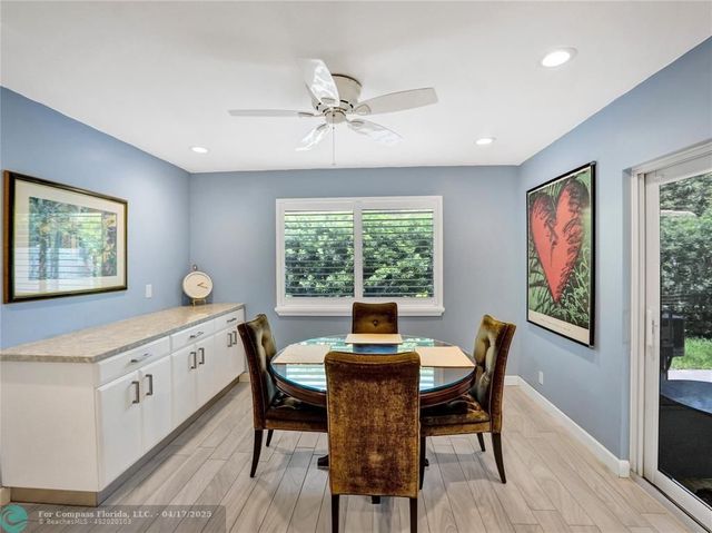 a dining room with furniture a large window and wooden floor