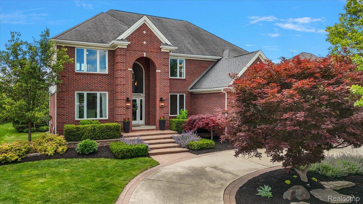 1422 Galena Rochester, MI 48306 - Photo 2 of 73 Brick exterior with a prominent arched entry, surrounded by manicured landscaping