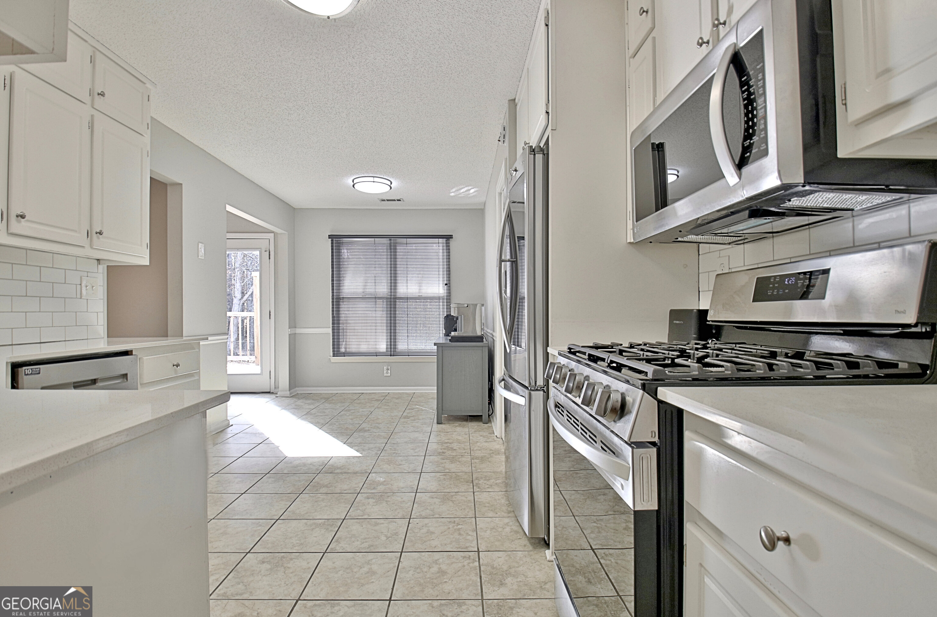 104 Blue Ridge Drive Newnan, GA 30265 - Photo 26 of 60 a kitchen with stainless steel appliances granite countertop a stove and a refrigerator