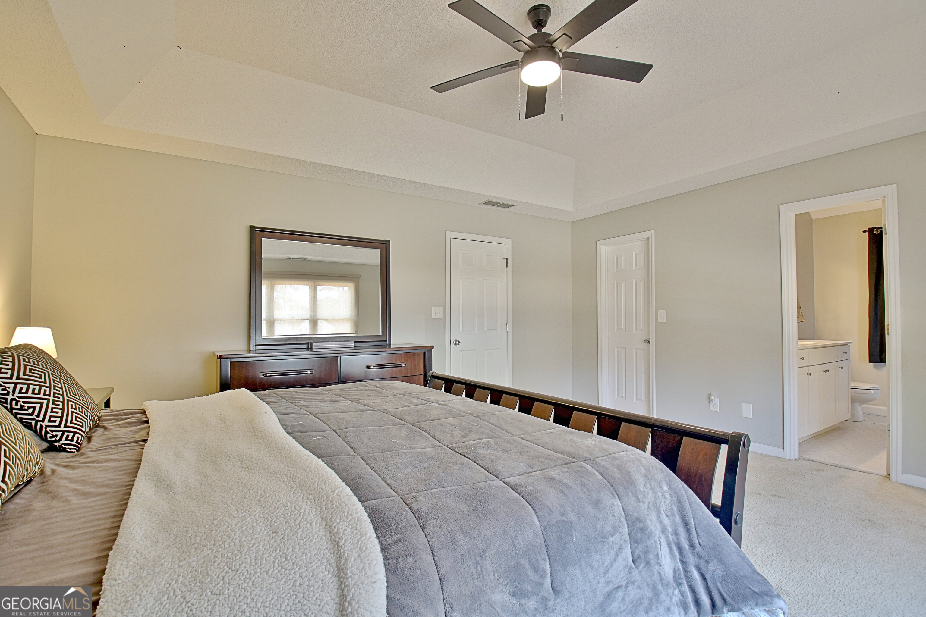 104 Blue Ridge Drive Newnan, GA 30265 - Photo 33 of 60 a bedroom with a large bed and a chandelier