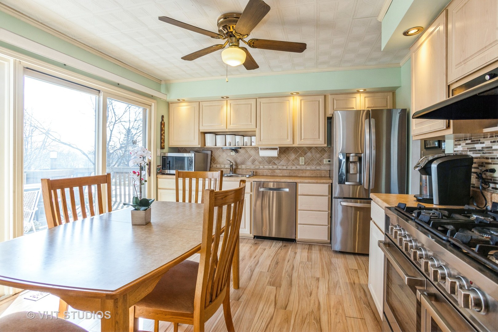 600 Edgemont Lane Hoffman Estates, IL 60169 - Photo 6 of 21 a kitchen with stainless steel appliances granite countertop a stove a refrigerator a kitchen island a sink dishwasher with a dining table and chairs with wooden floor
