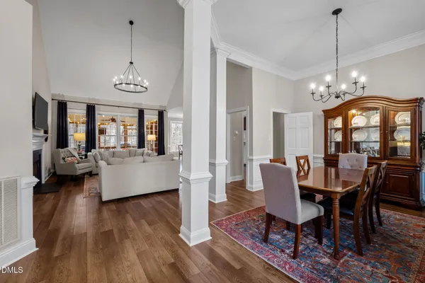 a view of a dining room with furniture a chandelier and wooden floor