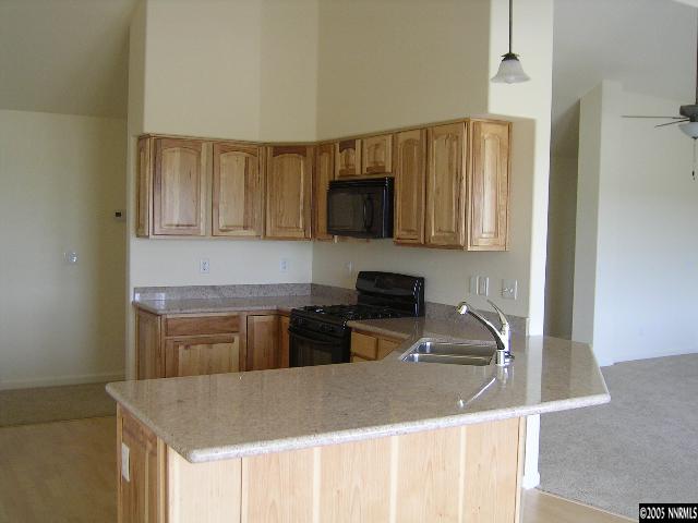 4439 Rancheria Road Fallon, NV 89406 - Photo 2 of 4 a kitchen with kitchen island granite countertop a stove top oven a sink a counter top space and cabinets