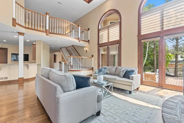 a living room with furniture and a large window with wooden floor