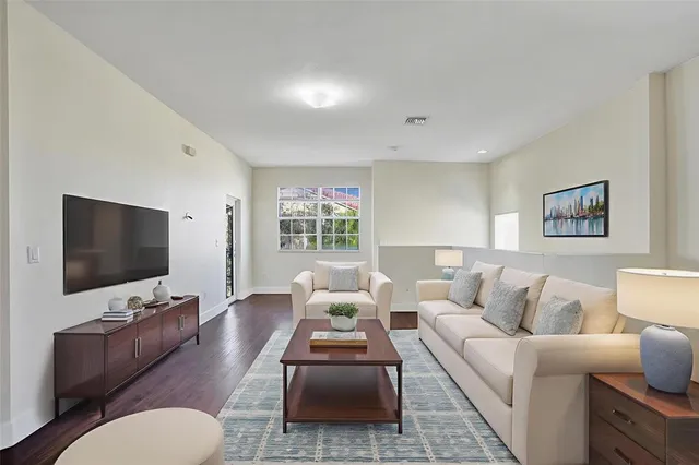 a living room with furniture a dining table and a flat screen tv