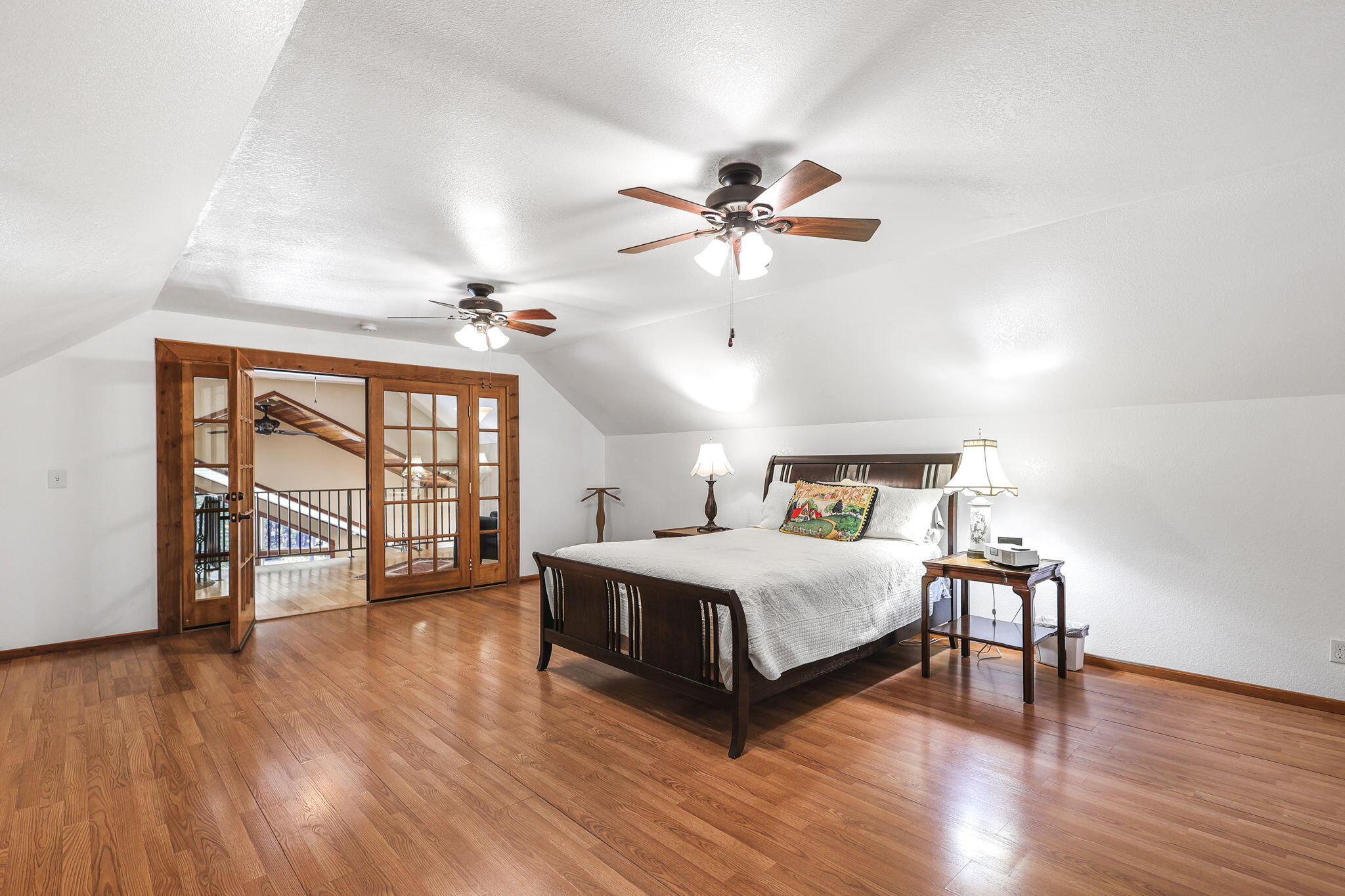 14703 Fern Road Whitmore, CA 96096 - Photo 7 of 48 a spacious bedroom with a bed a chandelier and a large window