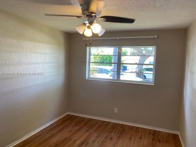 2060 Northeast 26th Street Lighthouse Point, FL 33064 - Photo 14 of 24 an empty room with wooden floor fan and windows