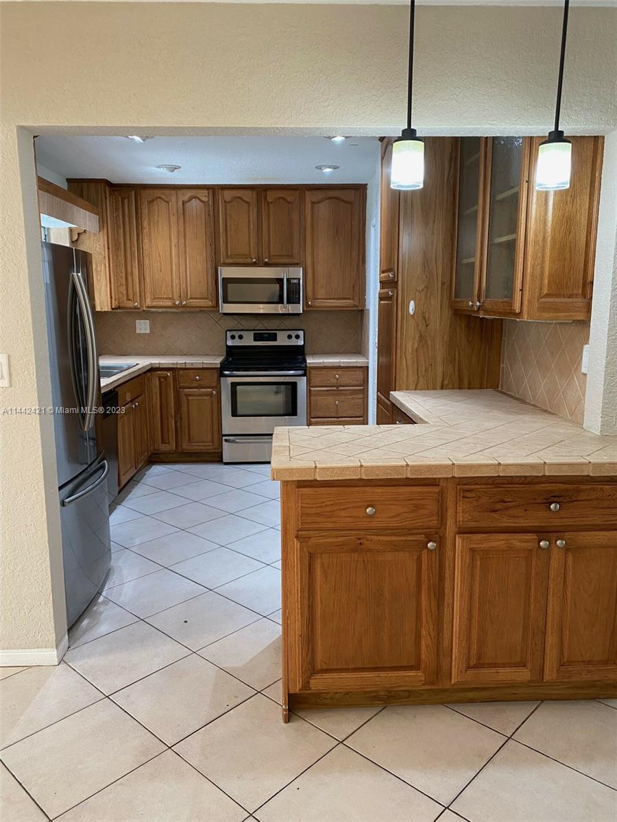 2060 Northeast 26th Street Lighthouse Point, FL 33064 - Photo 4 of 24 a kitchen with stainless steel appliances a refrigerator sink and microwave