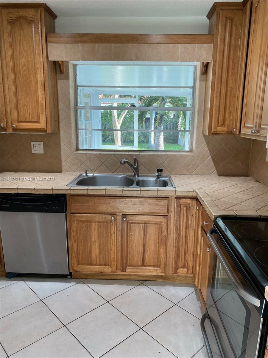 2060 Northeast 26th Street Lighthouse Point, FL 33064 - Photo 5 of 24 a kitchen with granite countertop a stove a sink and a microwave
