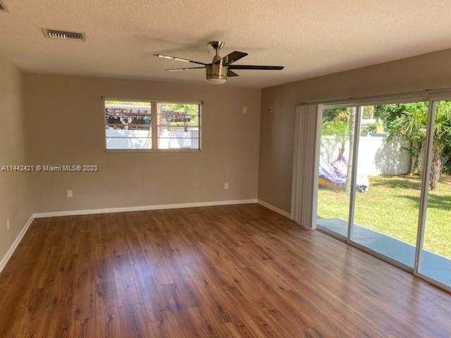 2060 Northeast 26th Street Lighthouse Point, FL 33064 - Photo 9 of 24 an empty room with wooden floor fan and windows