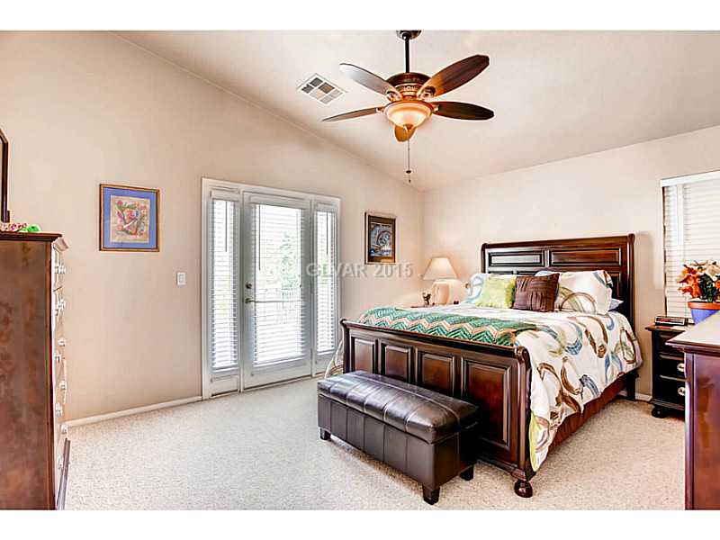 936 Midpride Street Las Vegas, NV 89144 - Photo 17 of 33 Master Bedroom. Vaulted ceilings, fan and a French door with side panels to the balcony.