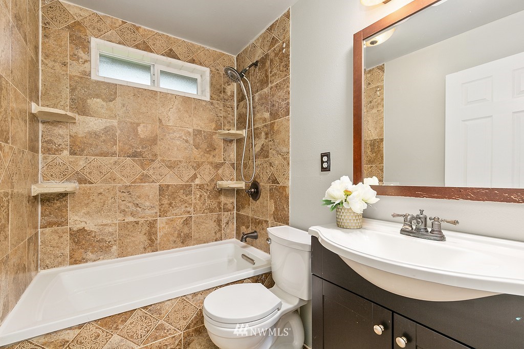 631 219th Place Southwest Bothell, WA 98021 - Photo 10 of 21 a bathroom with a sink a toilet a mirror a bathtub and shower