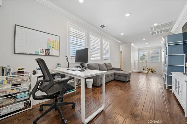 a view of a workspace with furniture and wooden floor