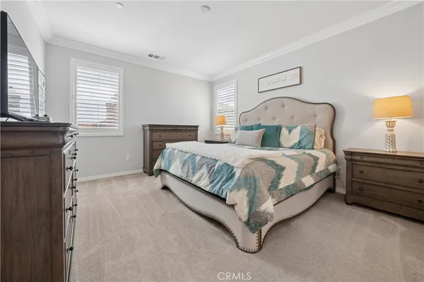 a bedroom with a bed and a lamp on the dresser