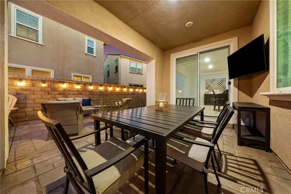 a view of a patio with table and chairs with wooden floor and flat screen tv