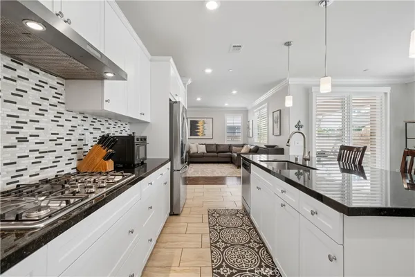 a kitchen with stainless steel appliances kitchen island granite countertop a sink and a stove