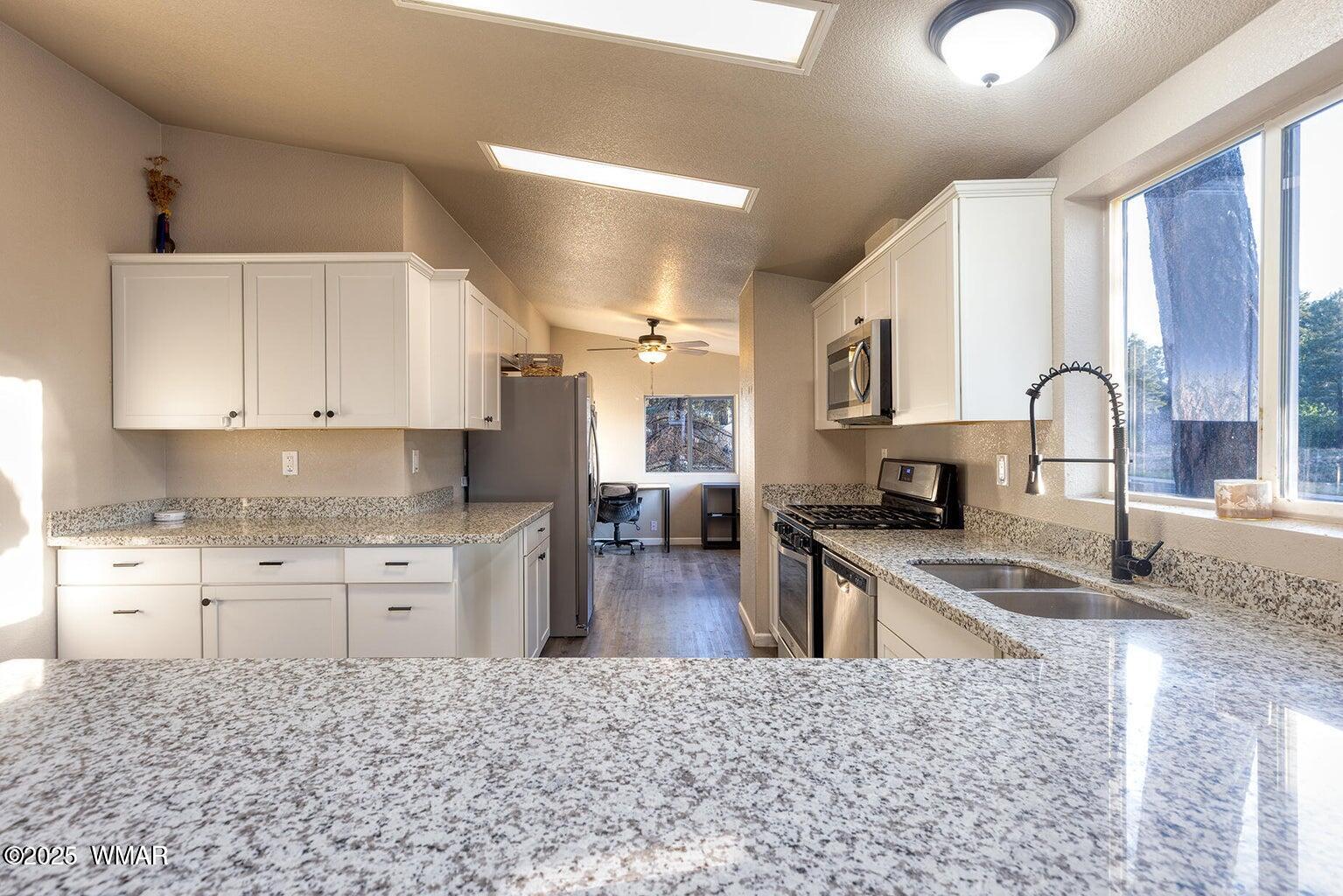 430 Timber Ridge Loop Show Low, AZ 85901 - Photo 8 of 27 a kitchen with granite countertop a stove sink and cabinets
