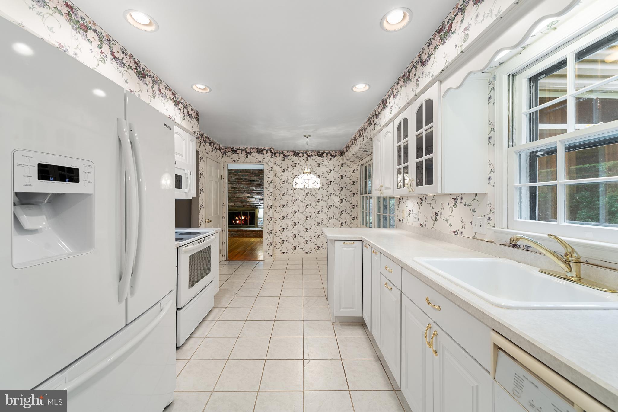1643 Homewood Road Annapolis, MD 21409 - Photo 22 of 59 a large white kitchen with a large window a sink and a stainless steel appliances