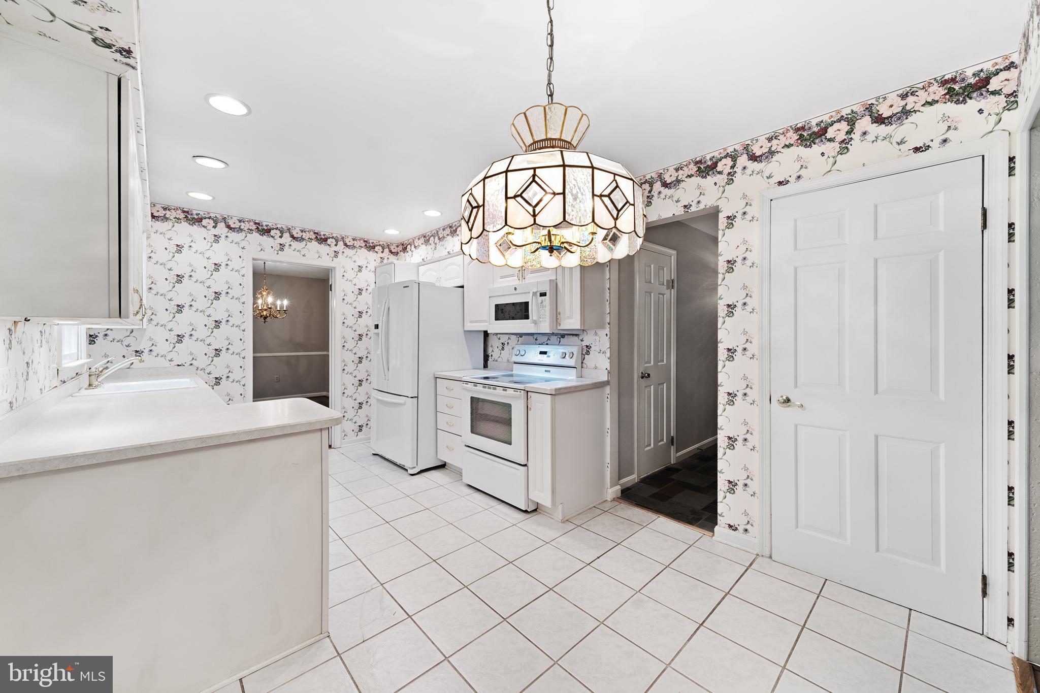 1643 Homewood Road Annapolis, MD 21409 - Photo 25 of 59 a kitchen with stainless steel appliances a stove a sink dishwasher a refrigerator and a dining table with wooden floor