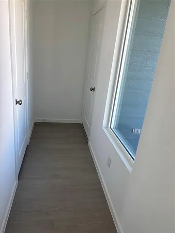 a view of a hallway with wooden floor and staircase