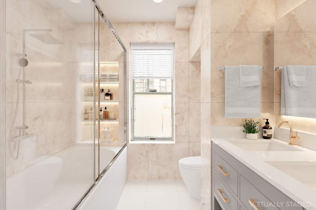 517 East 87th Street, Unit TRIPLEX Manhattan, NY 10128 - Photo 12 of 24 a bathroom with a tub sink toilet and a shower