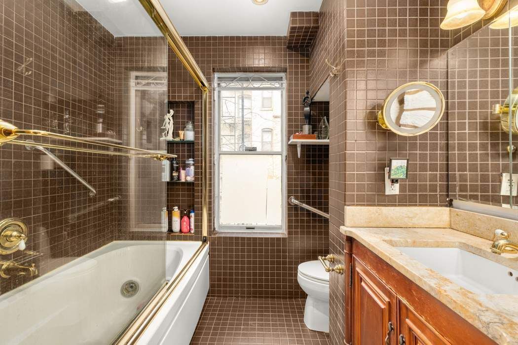 517 East 87th Street, Unit TRIPLEX Manhattan, NY 10128 - Photo 13 of 24 a bathroom with a granite countertop bathtub sink vanity mirror and toilet