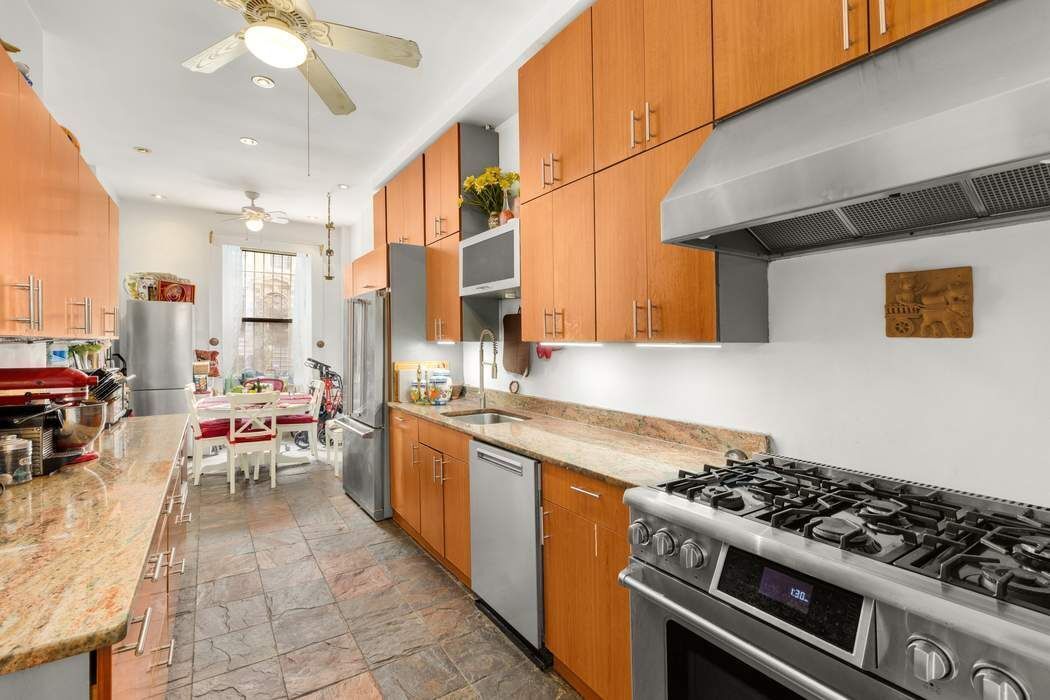 517 East 87th Street, Unit TRIPLEX Manhattan, NY 10128 - Photo 8 of 24 a kitchen with stainless steel appliances a stove a sink and a refrigerator