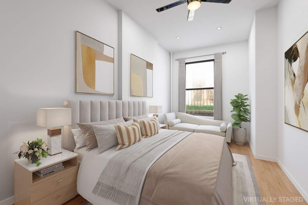 517 East 87th Street, Unit TRIPLEX Manhattan, NY 10128 - Photo 9 of 24 a bedroom with bed a chandelier and a window