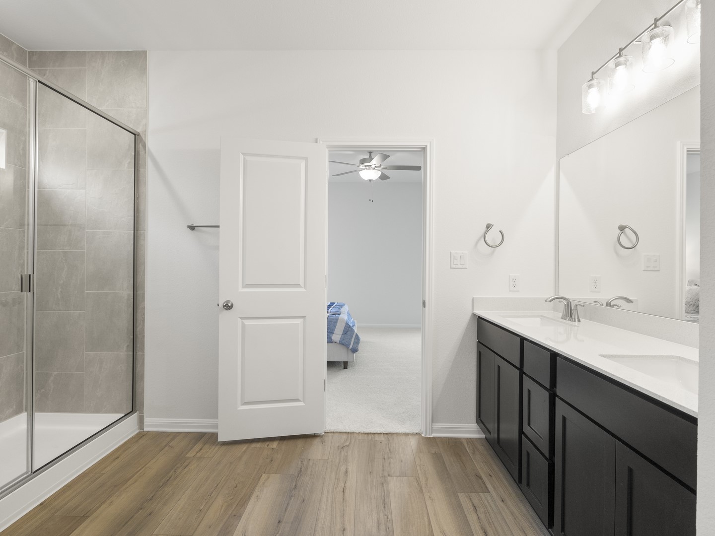 112 Mathew Street Bertram, TX 78605 - Photo 19 of 32 A well-appointed primary bathroom showcases a dual vanity and a contemporary glass-enclosed shower.