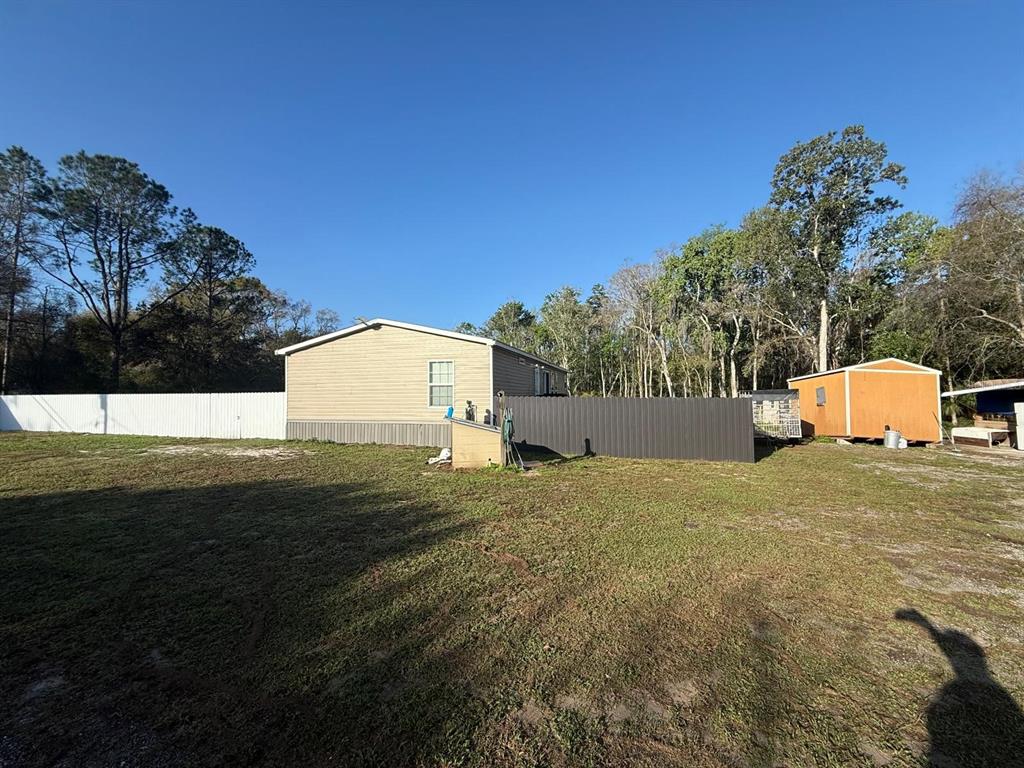 17151 Lemon Street Spring Hill, FL 34610 - Photo 15 of 18 a backyard of a house with a yard and garage