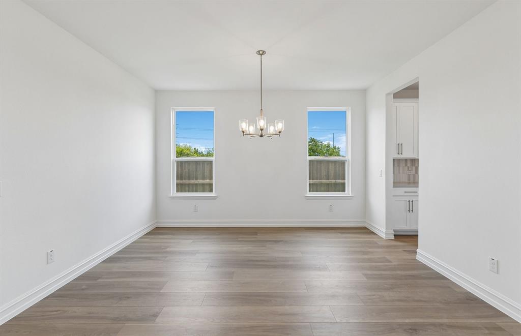 11220 Abbotsbury Road Fort Worth, TX 76052 - Photo 3 of 32 an empty room with wooden floor and windows
