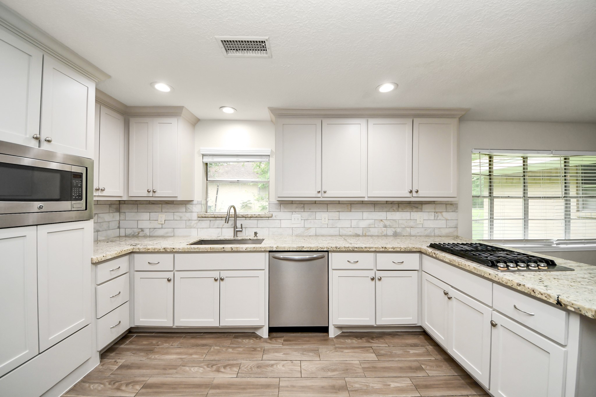 19435 Interstate 45 Spring, TX 77388 - Photo 10 of 24 a kitchen with granite countertop white cabinets and white appliances