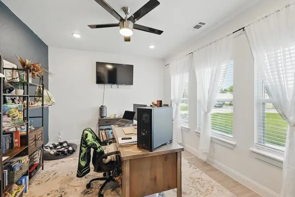 a view of a workspace with furniture and a window