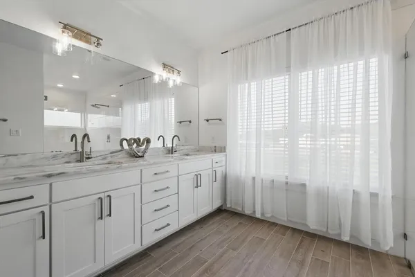 a bathroom with double sink shower and a mirror