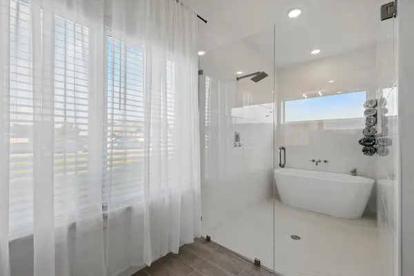 a bathroom with a bathtub a shower and a sink