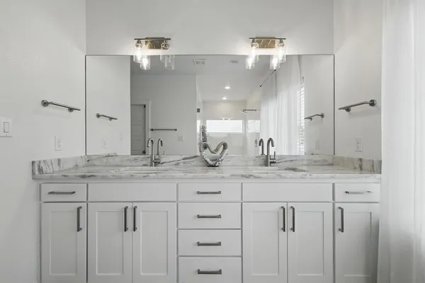 a bathroom with a granite countertop sink mirror and shower