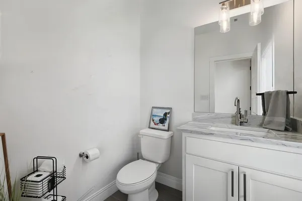 a bathroom with a granite countertop toilet sink and mirror