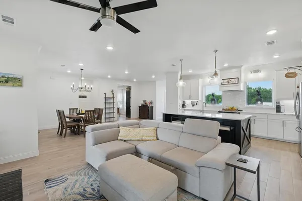 a living room with furniture and a view of kitchen