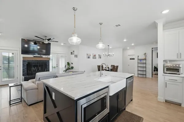 a large kitchen with kitchen island a stove a sink a center island a table and chairs